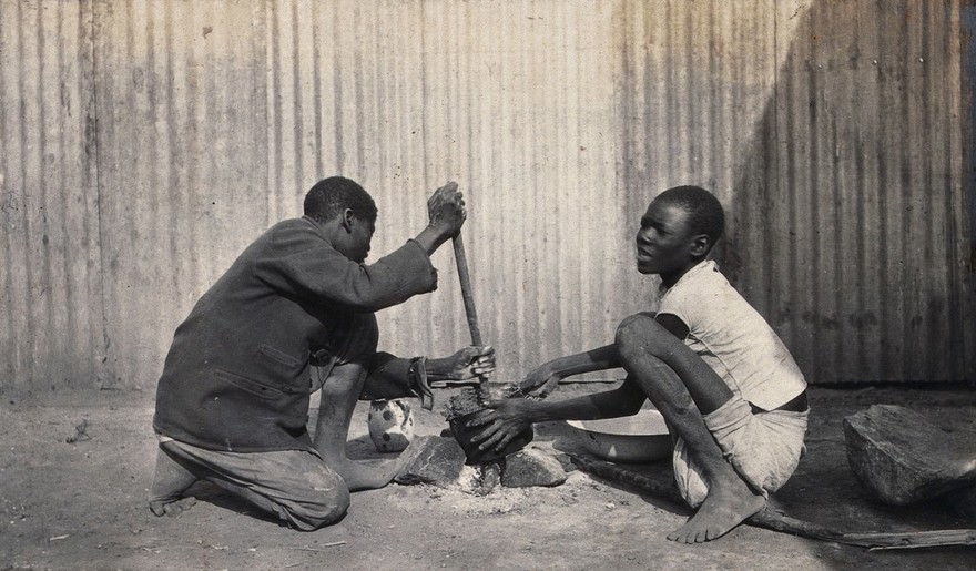 Umtali, Zimbabwe: two African boys stirring a cooking pot. Photograph by J. Lomas, 1905.