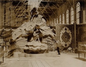 view The 1904 World's Fair, St. Louis, Missouri: the Belgian pavilion: a sculpture showing a man with a gun hiding in a cave, tracked by a man with a dog. Photograph, 1904.