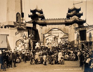 view The 1904 World's Fair, St. Louis, Missouri: the Pike (an avenue of amusements): costumed performers, including men and women on camels and an elephant, posing in a group. Photograph, 1904.