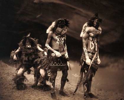 Three Navajo men proceeding as war gods: Tonenili, Tobadzischini and Nayenezgani. Photograph by Edward S. Curtis, 1904.