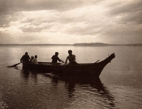 Salish people in a canoe on Puget Sound, North America. Photograph by Edward S. Curtis, ca. 1900.