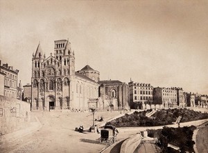 view Angoulême Cathedral, France; showing situation on a road adjacent to other town buildings. Photograph (by Édouard Baldus?), ca. 1860.