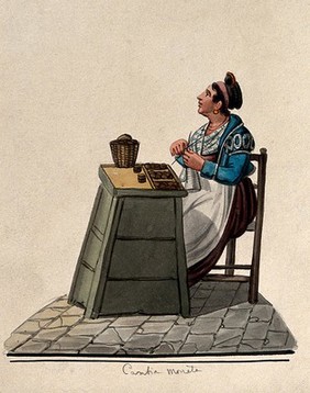 A women is sitting knitting at a table in the street with money on it in trays. Watercolour.