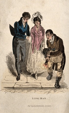 A man with a burning torchlight is guiding two people down the kerb and across the road. Coloured etching.