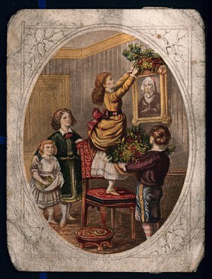 view A child holds a large bunch of holly and two others watch as a young woman stands on a chair to reach the picture she is decorating for Christmas. Colour process print.