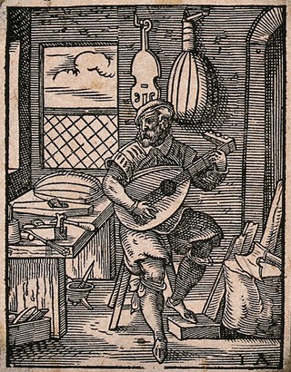A lute-maker testing one of the lutes in his workshop: other musical instruments are hanging on the walls, and there are tools on and around the workbench. Woodcut by Jost Amman, 1568.