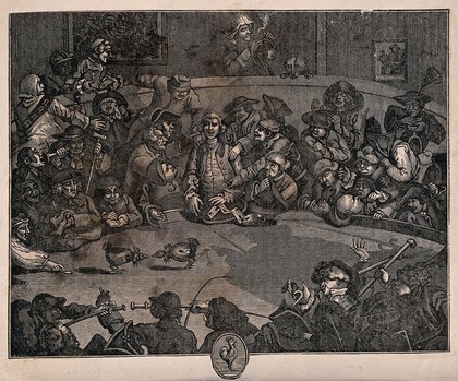 Men are gathered around in a circle watching two cocks fight one another. Wood engraving after W. Hogarth.