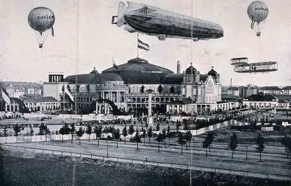 International Airship Exhibition, Frankfurt, 1909: a Zeppelin airship, an aeroplane and two balloons airborne over the exhibition site. Process print.