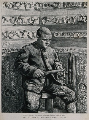 view Wormwood Scrubs Prison, London: a prisoner in the chain-room where manacles are stored: he is cleaning them. Process print after Paul Renouard.