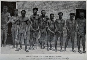 view Nine male prisoners in the Congo standing against a wall joined by chains around their necks. Process print after W.E. Geil.
