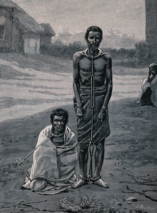 A man in Africa standing and another sitting on the ground, both have chains around their necks and ankles. Process print after L. Rousseau.