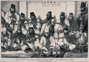 view Fourteen male prisoners in Persia sitting on the ground in a group bound together at the neck by chains, with an armed guard. Wood engraving, 1873, after Evelyn H. Ellis.