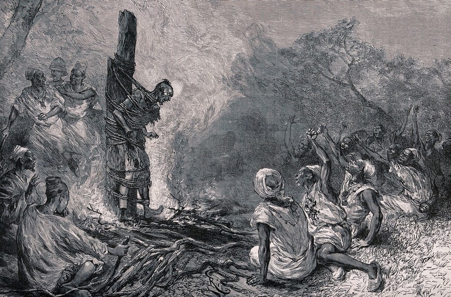 An African man burnt on a stake surrounded by other Africans and a white soldier in the background. Wood engraving by Riou.