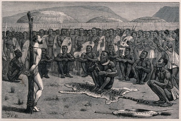 Ernest Grandier, a prisoner of the Zulus, stands naked and tied to a post before the tribe awaiting judgement from the chief he has been brought before. Wood engraving by J.C.D.