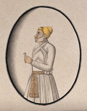 A Mughal courtier with a yellow turban holds an ornament (?). Watercolour drawing by an Indian artist.