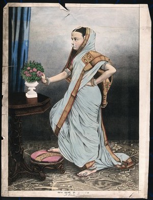 view An Indian woman poses in front of a table on which is placed a vase of roses. Chromolithograph by an Indian artist,18--.