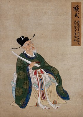 A Chinese figure, seated, wearing green robes richly decorated with lotus flower designs in gold thread with blue border and black hat. Painting by a Chinese artist, ca. 1850.