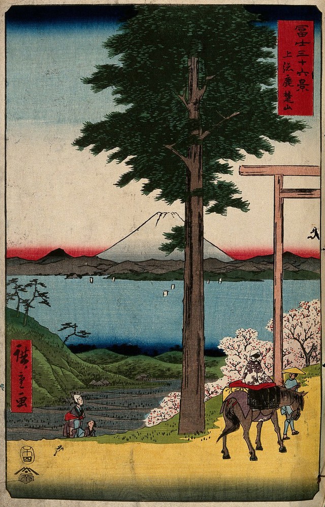 Fuji seen from Kazusa province across the bay from Edo; a woman is led on horseback through a shinto gate. Colour woodcut by Hiroshige, 1858.