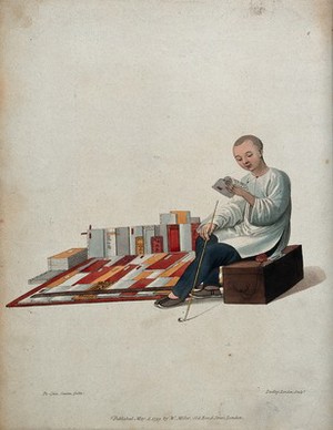 view A Chinese bookseller seated on a box in the street, reading in front of his books. Coloured stipple engraving by J. Dadley after Pu-Qua.