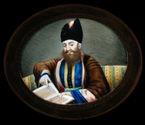 An Indian (?) man seated, reading a book. Watercolour.