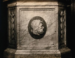 view Aesculapius: the Greek god of healing: his head in bas-relief on a marble soda fountain in use in the Baildon & Son pharmacy, Edinburgh. Photograph by Francis Caird Inglis, 1920/1935, of a sculpture, 1860.