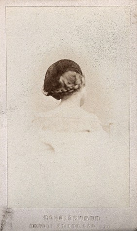 A girl wearing a hairnet, with plaited hair: the back of her head: a vignetted head-and-shoulders portrait. Photograph by O. Schliepmann, 1870/1890.