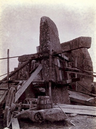 Stonehenge, England: the straightening of a leaning stone which is attached to a wooden frame and pulleys: partly raised. Photograph, 1901.