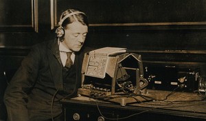 view The 'Optophone', a reading device for the blind, invented by E. E. Fournier D'Albe: demonstrated in use by a man. Photograph, ca. 1921.