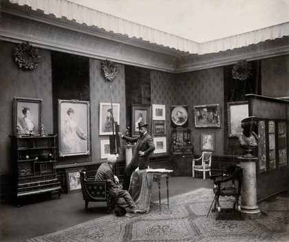 Vienna, Austria: a showroom in which paintings and furniture are displayed, visited by two men. Photograph by J. Löwy.