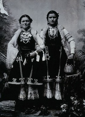 Two Bulgarian women arm-in-arm wearing national dress.