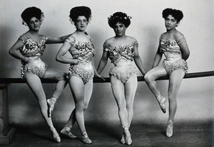 view Four young woman acrobats (?), posing on a bar in a photographic studio.