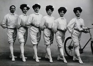 view Five young women and a young man, posing in acrobats' costume, in a photographic studio.