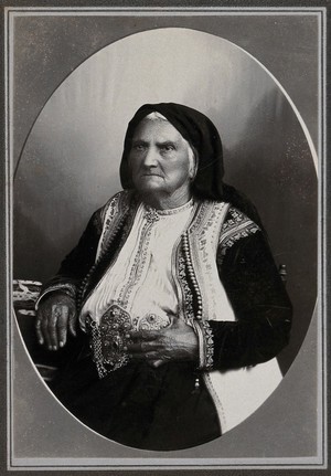 view A Montenegrin woman wearing national dress with a large metal belt.