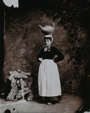 view A Basque woman posing with an earthenware jug on her head.