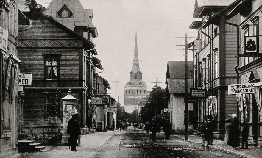 A street of wooden houses in Mora, with a church terminating the vista.