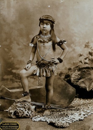 view A child of an Amazonian Indian tribe, standing on a leopard skin, in a photographic studio.