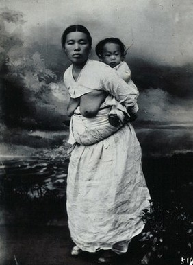 A Korean (?) woman, carrying a baby on her back.