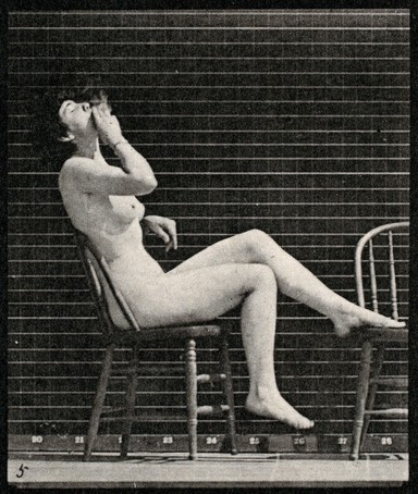 A woman sitting naked on a chair and smoking. Collotype