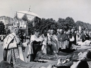 view Lourdes, France: the blessing of sick pilgrims by a priest bearing a monstrance, followed by a procession. Photograph, ca. 1937.