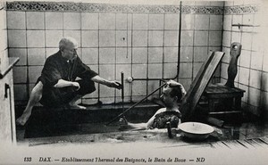 view Dax, France: a patient in a mud bath, in a thermal establishment. Photographic postcard, ca. 1920.