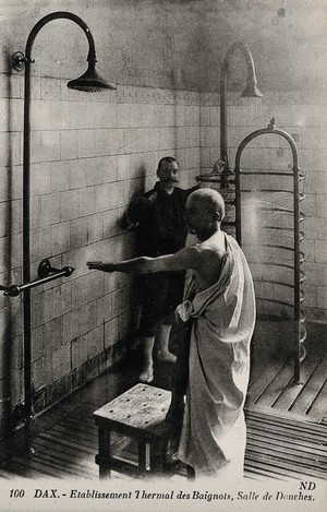 view Dax, France: a male patient in the shower room of a thermal establishment. Photographic postcard, ca. 1920.