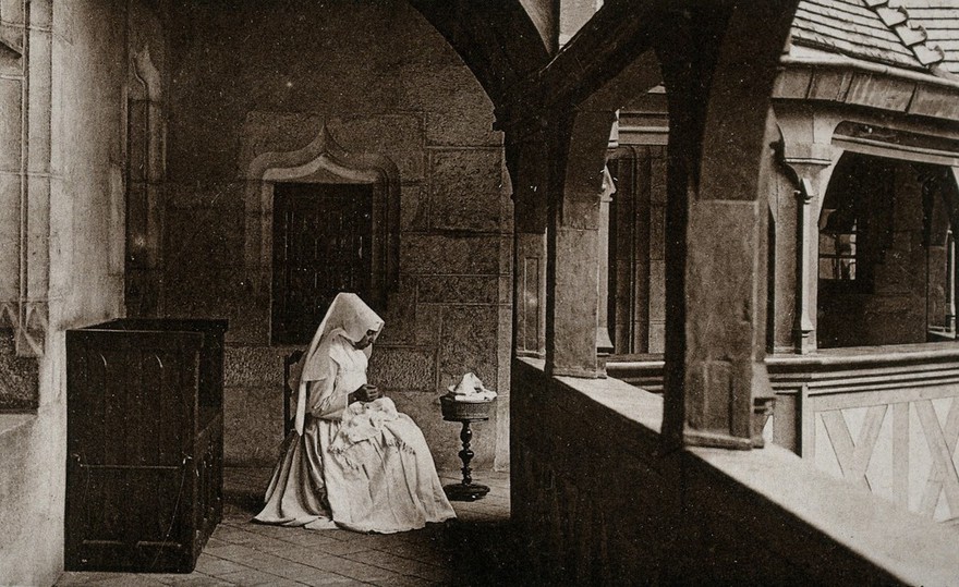 Beaunes, France: a nurse sewing in the first floor gallery of the Hôtel Dieu. Photographic postcard, ca. 1930.