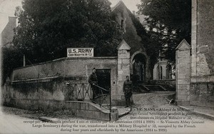 view The Abbaye de Saint Vincent transformed into a military hospital in Le Mans, France; two soldiers in the foreground. Photographic postcard, 1920.