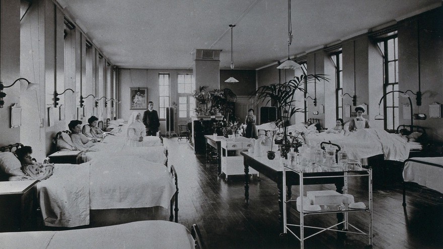 St. John's and St. Elizabeth's Hospital, London: women patients in a surgical ward, with members of staff. Photographic postcard, ca. 1915.