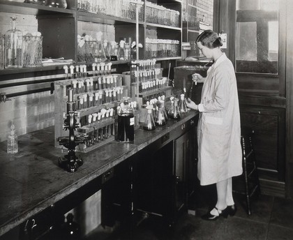 Philadelphia College of Pharmacy and Science: a woman making experiments in test tubes. Photograph, ca. 1933.