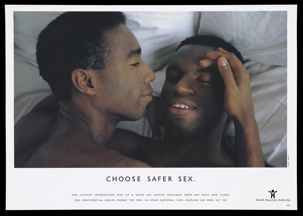 Two black men lie with their heads together on a pillow; an advertisement for safe sex by the Health Education Authority for the National Aids Helpline. Colour lithograph.