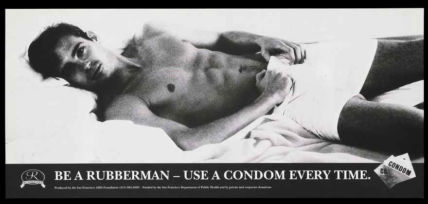 A man lying on a bed with his hands by his shorts with two condom packets; advertisement for condoms and safe sex by the San Francisco AIDS Foundation. Lithograph, 1988.