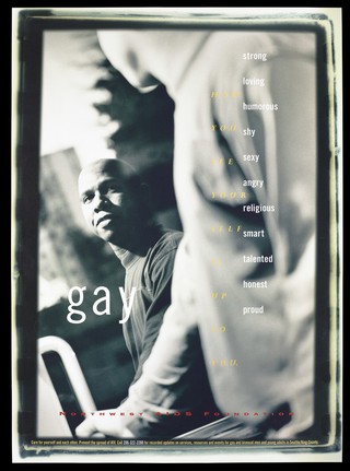 A black man looks up at the side profile of another man out of focus in the foreground representing an advertisement for the Northwest AIDS Foundation. Colour lithograph by Heath Printers.