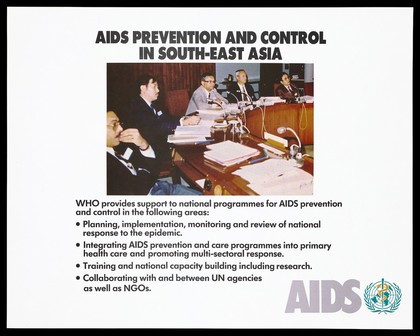 Men sitting at desks with speakers representing a World Health Organization meeting about AIDS prevention programmes in South-East Asia with a list of support activities provided by the organization. Colour lithograph, ca. 1995.