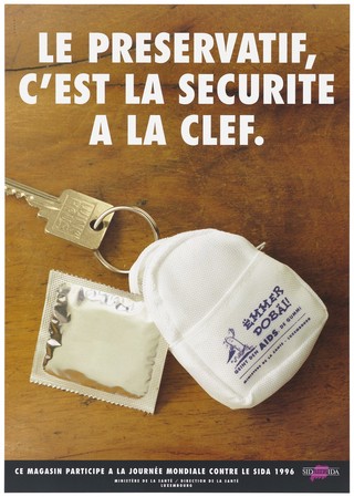 A silver condom packet emerging out of a small white bag attached to a key ring with the comment that your condom is safe with your keys; the bag bears an illustration of a running condom holding an umbrella; an advertisement for safe sex by the Ministère de la Santé in association with World AIDS Day 1996. Colour lithograph.